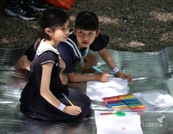 베이비타임즈가 주최한 다문화어린이 그림대회에서 심각한 모습으로 작품 구상을 하고 있는 두 자매.