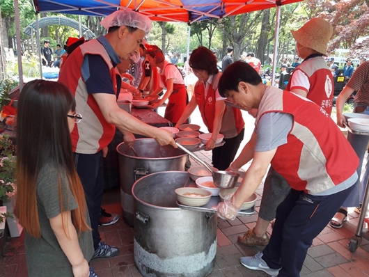 롯데푸드 청주공장 샤롯데 봉사단원들이 15일 청주 중앙공원에서 무료 급식 봉사를 진행하고 있다. (사진제공=롯데푸드)