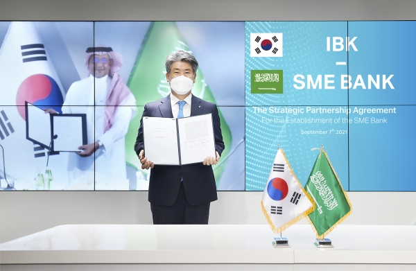 윤종원 기업은행장(오른쪽)과 무함마드 알 투와이즈리 사우디 SME Bank 이사회의장(왼쪽)이 비대면 협약식을 마치고 기념촬영을 하고 있는 모습. (사진=IBK기업은행 제공)
