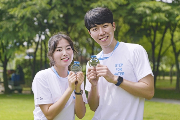 진은 굿네이버스 희망걷기대회 서포터즈 김보은 씨, 서동욱 씨가 참여 인증 메달을 들고 기념사진을 찍고 있는 모습 (사진 왼쪽부터) (사진=굿네이버스 제공)